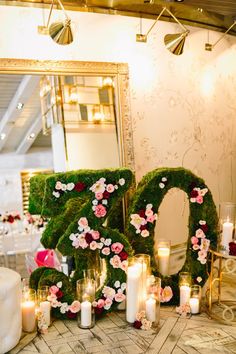 flowers and candles are arranged in the shape of the number twenty two, surrounded by moss