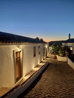 a cobblestone walkway with lights on the side