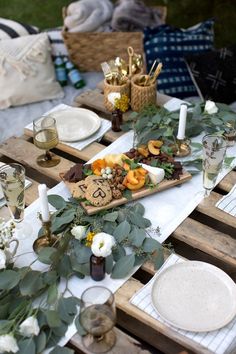 an outdoor table set with plates, glasses and napkins for a dinner or party