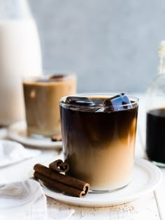 there is a cup of coffee on the table with cinnamons and milk in it