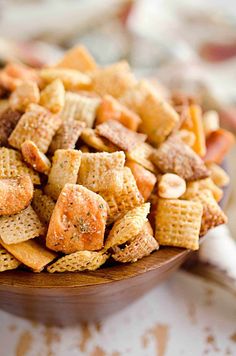 a wooden bowl filled with cheetos on top of a table