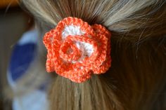 a close up of a woman's hair with a crocheted flower on it