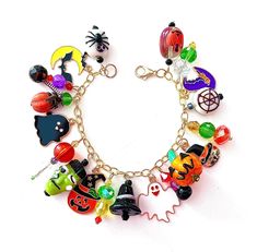 This happy and colorful Halloween charm bracelet is handcrafted by myself and a one of a kind original.  The gold plated chain is 7 3/4 inches long with 19 drops containing  pumpkins, jack o lanterns,  ghosts, a monster, cat, moon, bats and lots of crystals so it sparkles as you move.  It contains an assortment of enamel charms, Lampwork beads, glass, acrylic and crystals.  If you need it shorter or longer just let me know, and I will adjust it to as close as possible to the size you desire. If Handmade Multicolor Bracelets For Halloween, Multicolor Novelty Bracelets For Halloween, Handmade Halloween Novelty Bracelets, Handmade Themed Bracelet For Halloween, Fun Multicolor Halloween Jewelry, Handmade Themed Halloween Bracelet, Handmade Themed Multicolor Jewelry, Handmade Multicolor Themed Jewelry, Handmade Halloween Charm Bracelet Gift