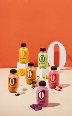 an assortment of juices and condiments on a table with the letter o in the background