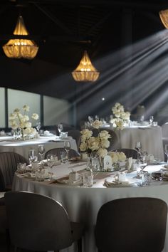 the tables are set with white flowers and place settings