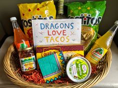 a basket filled with tacos, sauces and condiments next to a sign that says dragon's love tacos