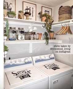 a washer and dryer sitting in a room next to some shelves with pictures on them