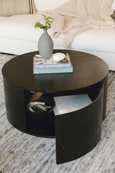 a coffee table with books and a vase on top