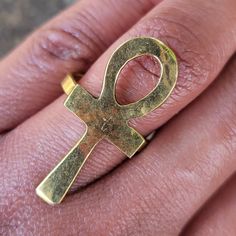 Adjustable brass ring from Nairobi, Kenya.  This ring is handmade by independent tribal designers in Nairobi, Kenya. The hammered ankh design on the ring is approximately 1 inch wide and approximately 1.75 inches long. The size of the ring is adjustable to fit multiple finger sizes. Second photo shows side by side comparison of Large Hammered Ankh and Small Hammered Ankh Rings. Last photo is a view of the back of the ring showing the adjustable brass band. Ankh Design, Nairobi Kenya, Brass Band, Brass Ring, Nairobi, Side By Side, Rings Statement, Kenya, Favorite Jewelry