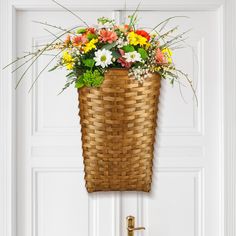 a basket hanging on the door with flowers in it