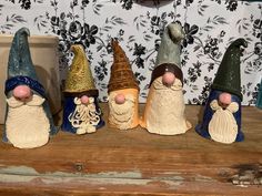 five gnomes sitting on top of a wooden table