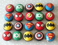 cupcakes decorated in the shape of batman and superman logos