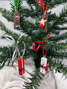 a christmas tree with ornaments hanging from it's branches in the shape of reindeers