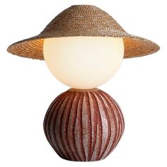 a lamp with a hat on top of it and a light bulb in the shape of a ball