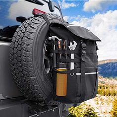 the tire bag is attached to the back of a jeep with tools hanging from it