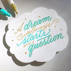 a pen and some writing on top of a piece of paper that says dream always starts with a question