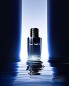 a bottle of cologne sitting on top of a table next to two blue pillars with light coming from them