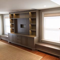 an empty living room with built in bookshelves