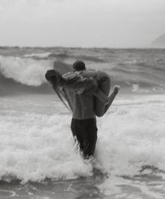 a man carrying a surfboard into the ocean