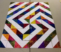 a piece of art made out of different colored papers and paper machs on top of a table