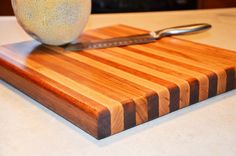 a cutting board with a knife on it and an apple sitting on top of it