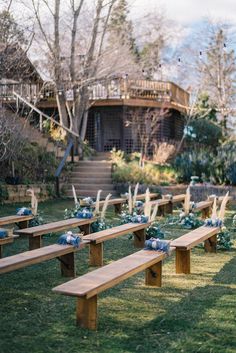 a row of wooden benches sitting on top of a lush green field