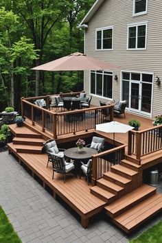 a deck with chairs and an umbrella in front of a house