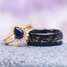 two wedding rings sitting on top of a rock with blue and white stones in them