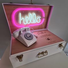 an open suitcase with a telephone in it and the word hello spelled out on top