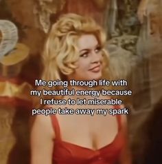 a woman in a red dress standing next to a painting with the words, me going through life with my beautiful energy because