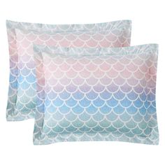 two pillow cases with mermaid scales in pastel blue, pink and green colors on them