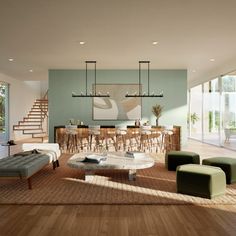 a living room filled with lots of furniture and a staircase leading up to the second floor