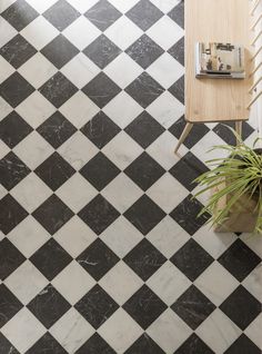 a black and white checkered tile floor with a wooden table next to it,