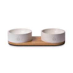 two white bowls sitting on top of a wooden tray