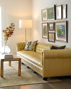 a living room filled with furniture and pictures hanging on the wall above it's coffee table