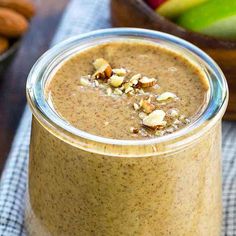 a glass jar filled with smoothie and nuts