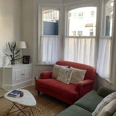 a living room with two couches and a coffee table in front of the window