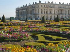 a large building with lots of flowers in front of it