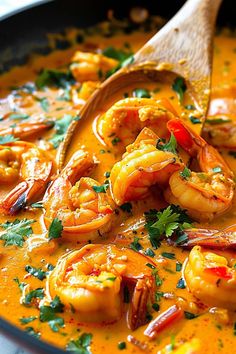 a wooden spoon in a bowl filled with shrimp