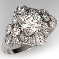 an antique style diamond ring with filigrees and diamonds on the sides, set in white gold