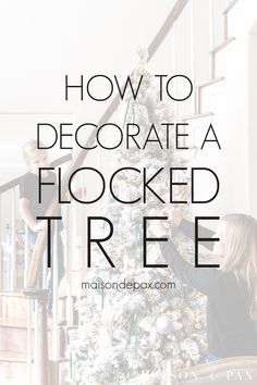 two people decorating a flocked tree with text overlay