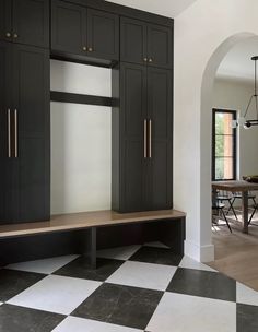 a black and white checkered floor in a room with cabinets on either side of the wall