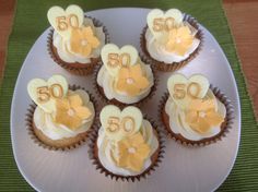 cupcakes decorated with flowers and the number 50 on them are sitting on a plate