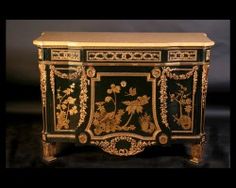 an ornate black and gold cabinet with flowers on it