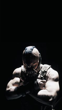 the dark knight rises movie poster with batman in his helmet and gloves, looking over his shoulder