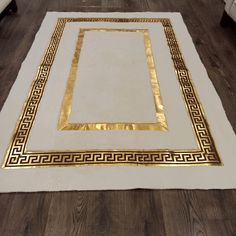 a white and gold area rug on the floor