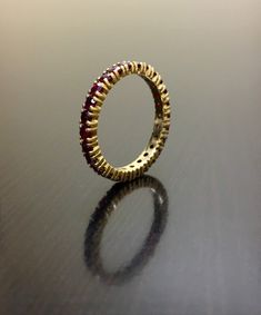 a gold and red ring sitting on top of a table