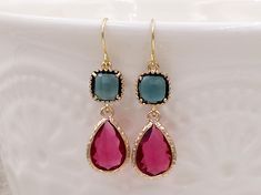 These are beautiful fuchsia pink and navy blue glass jewel earrings. The glass jewels golden plated framed all around. They hang underneath golden plated earwires.  The earrings measures about 42mm (1.65 inches) from the top of the ear wires to the bottom of the glass jewels.  They are wonderful idea for gift giving or as a little treat for yourself. Your earrings will presented in gift box and tied with ribbon. Measurement & Details: Total length: 42mm (1.5") Cushion cut jewel: 8mm Teardrop jewel: 18mm x 12mm Ear wires: golden plated earwires PLEASE NOTE: All Sales Are Final. No refunds, returns or exchanges; especially for health/hygiene reasons. If you need more quantity, please contact me with any questions. Thank you for visiting!  Visit my shop ~ thecharmjewelry https://www.etsy.com/ Gold Party Earrings With Birthstone, Pink Gemstone Accented Earrings For Party, Elegant Pink Gold Pink Sapphire Earrings, Multi-stone Pink Sapphire Jewelry For Gifts, Pink Sapphire Multi-stone Jewelry For Gifts, Pink Multi-stone Round Earrings, Navy Blue Earrings, Blue Wedding Jewelry, Crystal Teardrop Earrings