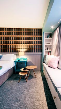 a bedroom with two beds and a table in the corner next to it on top of carpeted flooring