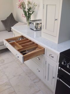 an open drawer in the middle of a kitchen counter